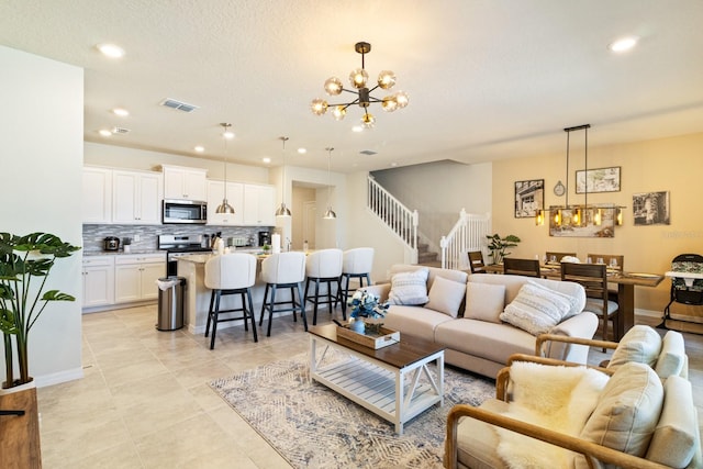 tiled living room with a notable chandelier