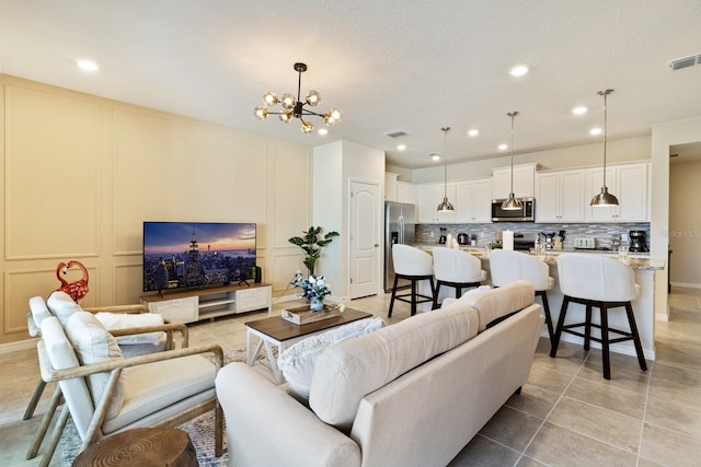 living room featuring light tile patterned floors and an inviting chandelier