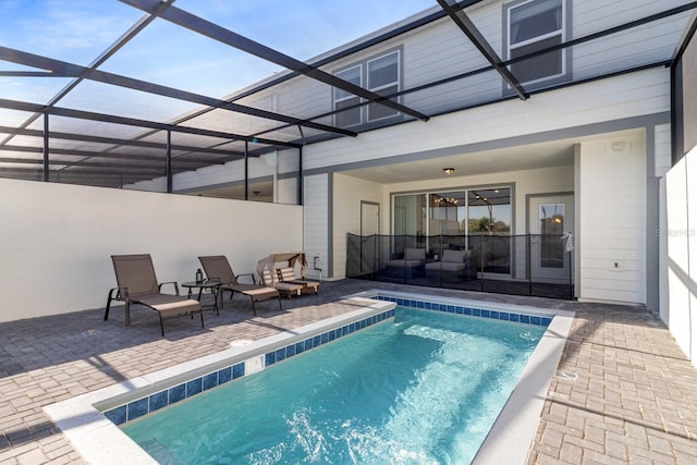 view of swimming pool featuring a lanai and a patio area