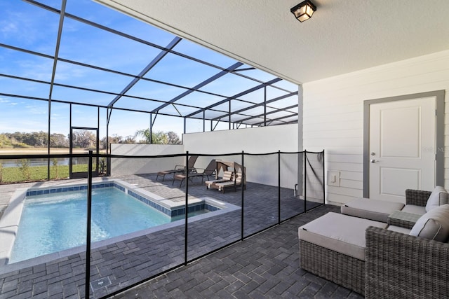 view of pool featuring an outdoor living space, a patio, glass enclosure, and a hot tub