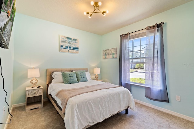 bedroom featuring an inviting chandelier and carpet