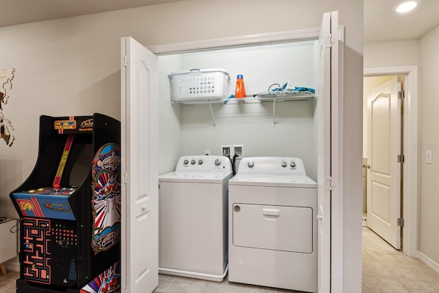 clothes washing area with light carpet and washer and dryer