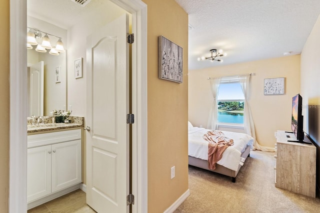 7143 Oakmoss Loop, Davenport, FL 33837 - bedroom with a sink, a textured ceiling, baseboards, and light colored carpet
