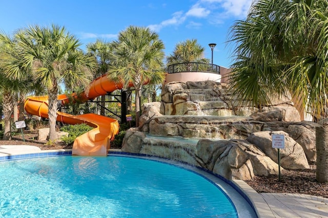 view of swimming pool with a water slide and pool water feature