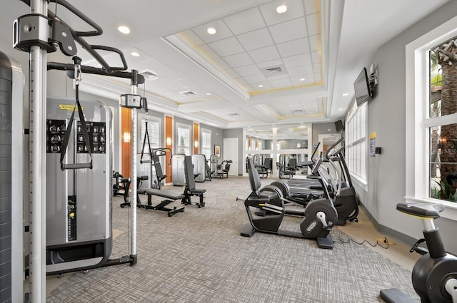 gym featuring carpet, a tray ceiling, ornamental molding, and coffered ceiling