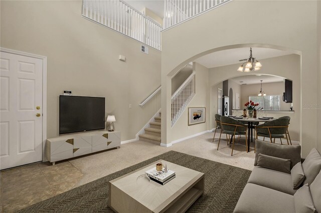 living room featuring tile patterned floors, an inviting chandelier, and a towering ceiling