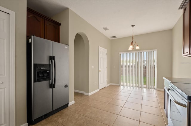 kitchen featuring stainless steel appliances, hanging light fixtures, light tile patterned floors, and dark brown cabinetry