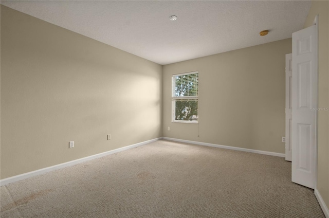 carpeted spare room featuring a textured ceiling