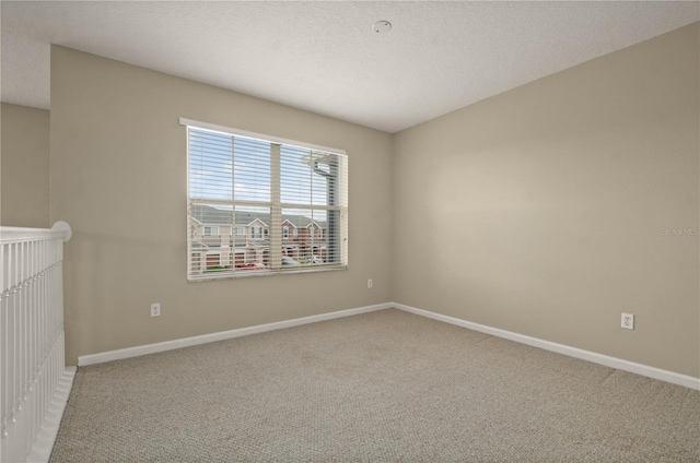 carpeted empty room with a textured ceiling