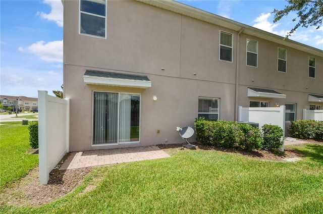 rear view of property with a patio and a lawn