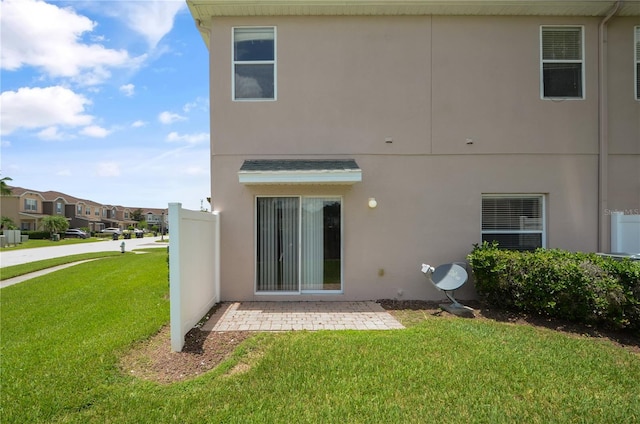 rear view of house featuring a patio and a yard