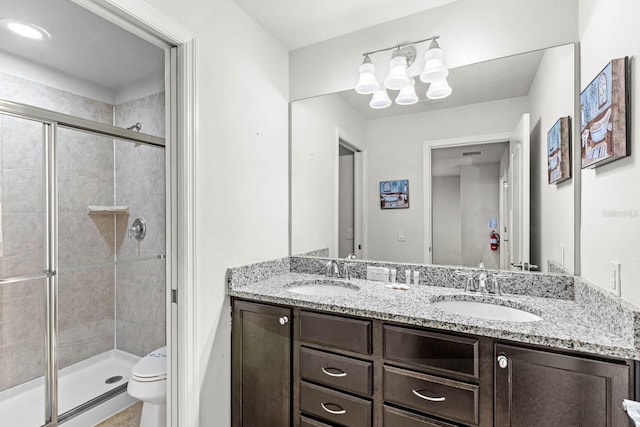 bathroom featuring vanity, an enclosed shower, and toilet