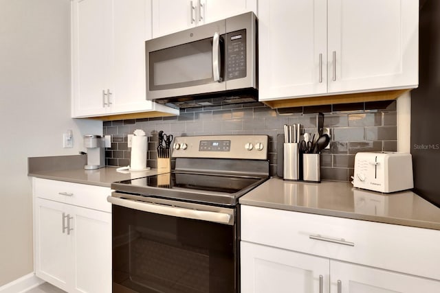 kitchen with stainless steel appliances, backsplash, and white cabinets