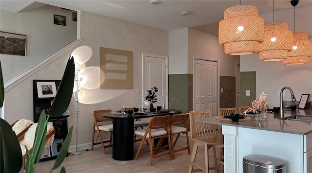 kitchen with light tile patterned flooring, pendant lighting, and sink