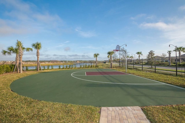 view of sport court featuring a yard and a water view