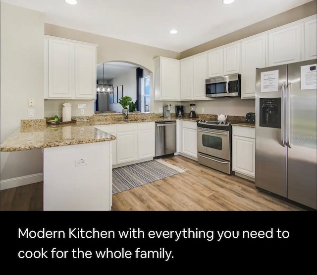 kitchen featuring kitchen peninsula, white cabinets, light hardwood / wood-style floors, and appliances with stainless steel finishes