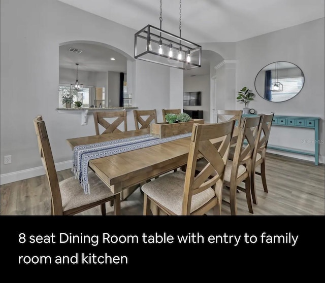 dining space with hardwood / wood-style flooring and a chandelier