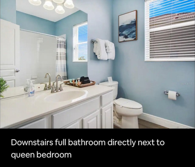 bathroom with vanity, curtained shower, and toilet