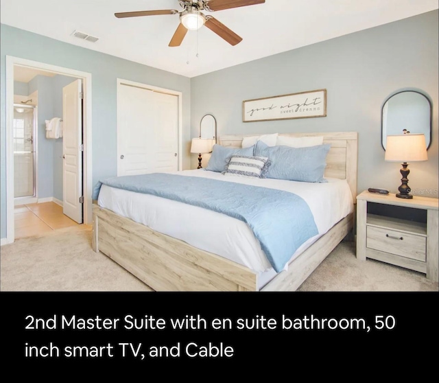 bedroom with ceiling fan, light colored carpet, and ensuite bathroom