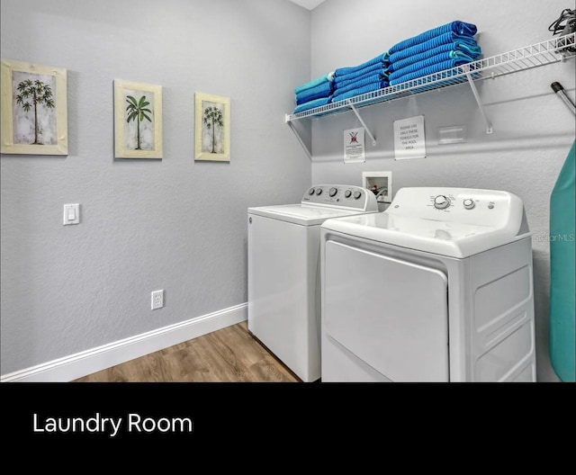 washroom with hardwood / wood-style floors and washer and dryer