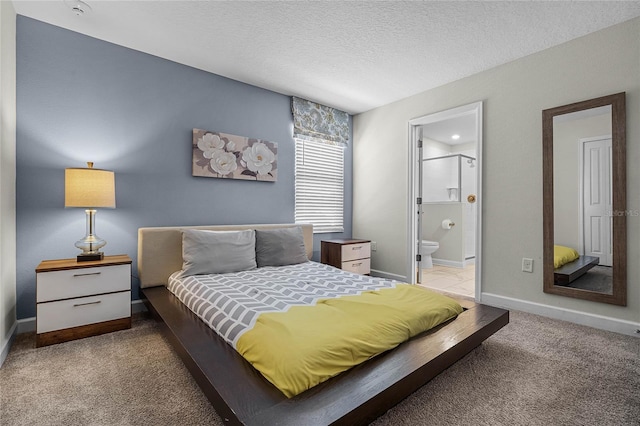 bedroom with light carpet, a textured ceiling, and ensuite bath