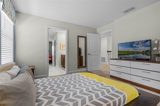 bedroom featuring ensuite bathroom, multiple windows, and a textured ceiling