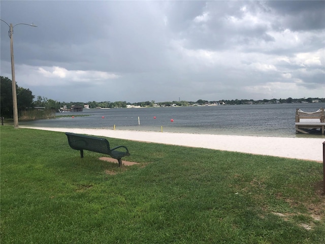 view of community with a lawn and a water view