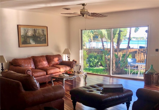 living room with a water view, ceiling fan, and wood-type flooring