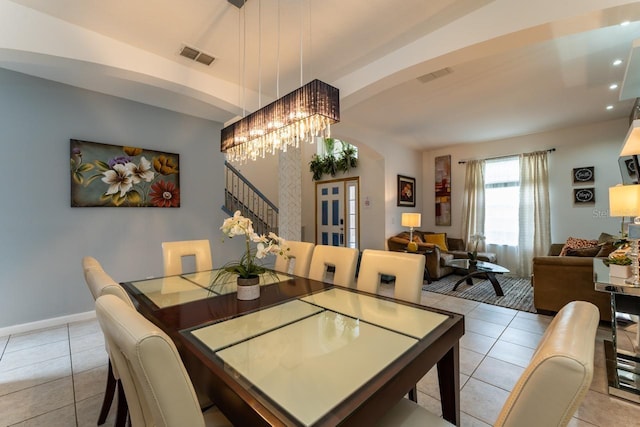 tiled dining room featuring a chandelier