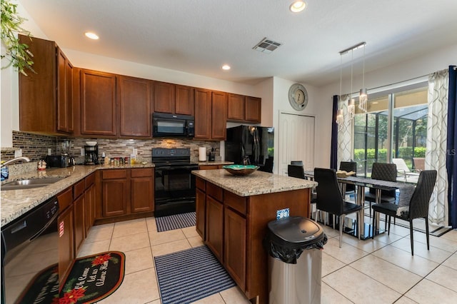 kitchen featuring decorative light fixtures, sink, decorative backsplash, and black appliances