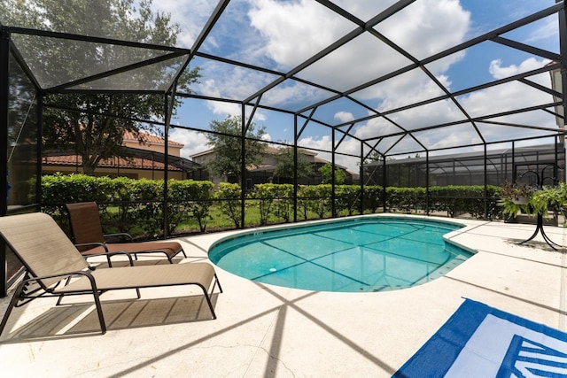 view of swimming pool with a patio area and glass enclosure