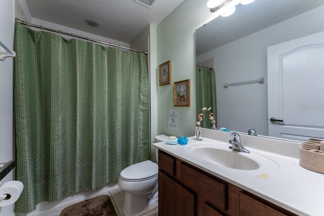 bathroom featuring a textured ceiling, toilet, vanity, and tile patterned flooring