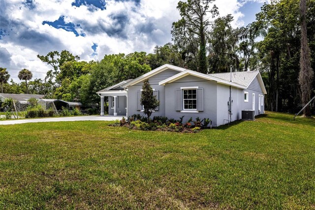 ranch-style home featuring central air condition unit and a front lawn