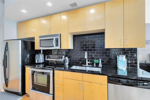 kitchen with stainless steel appliances, tasteful backsplash, sink, and light brown cabinets