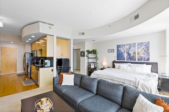 bedroom with stainless steel fridge and light wood-type flooring