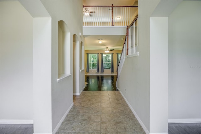 corridor featuring a high ceiling and light tile patterned floors