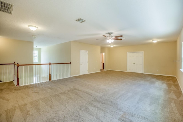 carpeted empty room featuring ceiling fan