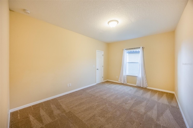 unfurnished room featuring a textured ceiling and carpet