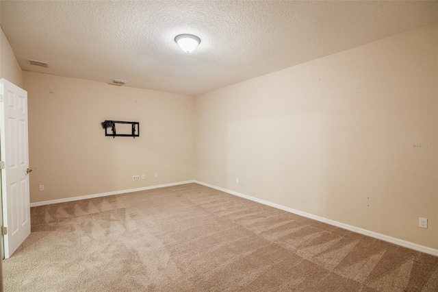 carpeted empty room featuring a textured ceiling