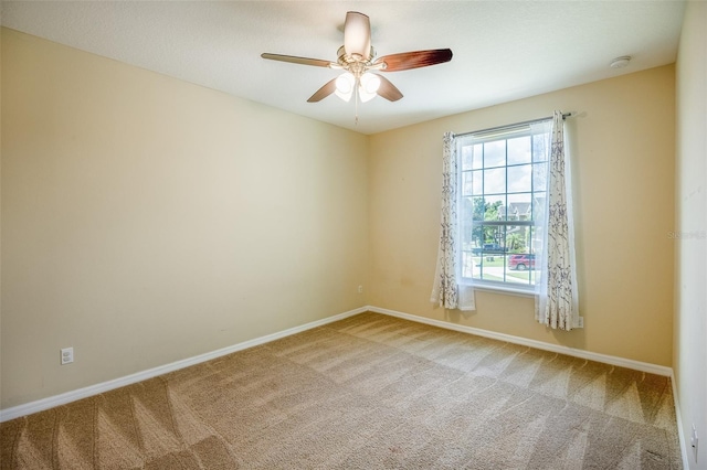 carpeted spare room featuring ceiling fan