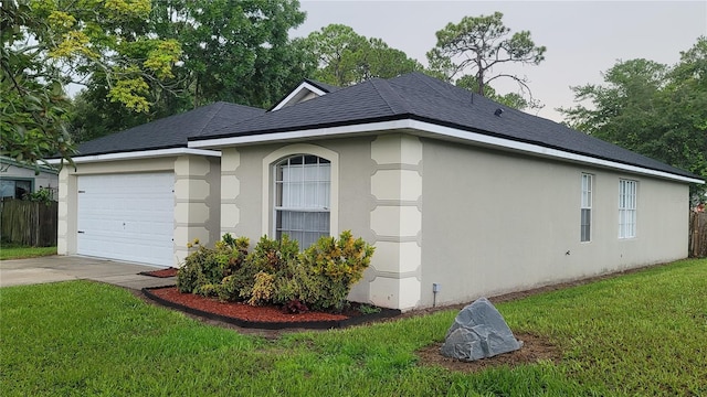 view of side of property featuring a shingled roof, a lawn, driveway, and stucco siding