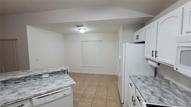 kitchen featuring light tile patterned floors, light stone counters, white appliances, and white cabinets