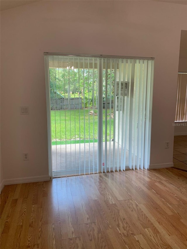 spare room featuring wood finished floors and baseboards