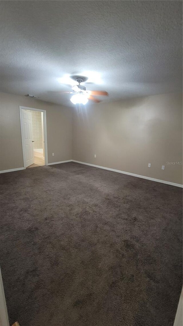 empty room featuring carpet floors, ceiling fan, and a textured ceiling