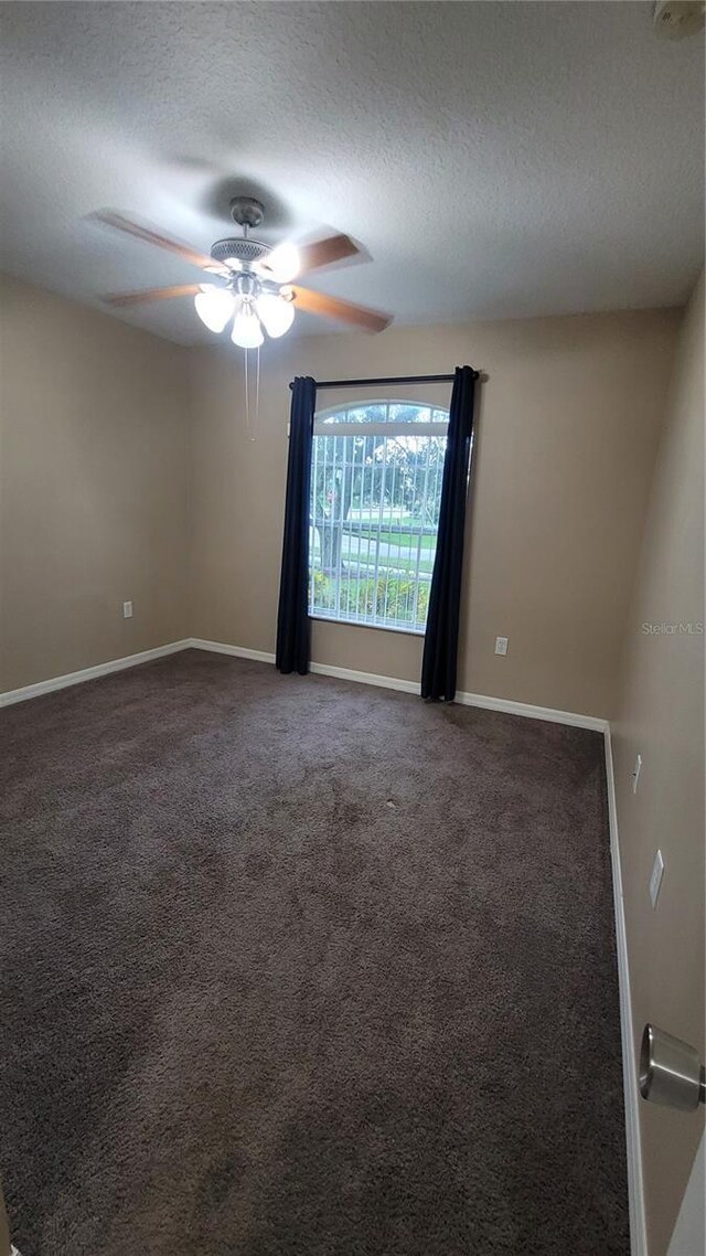 empty room featuring ceiling fan, carpet, and a textured ceiling