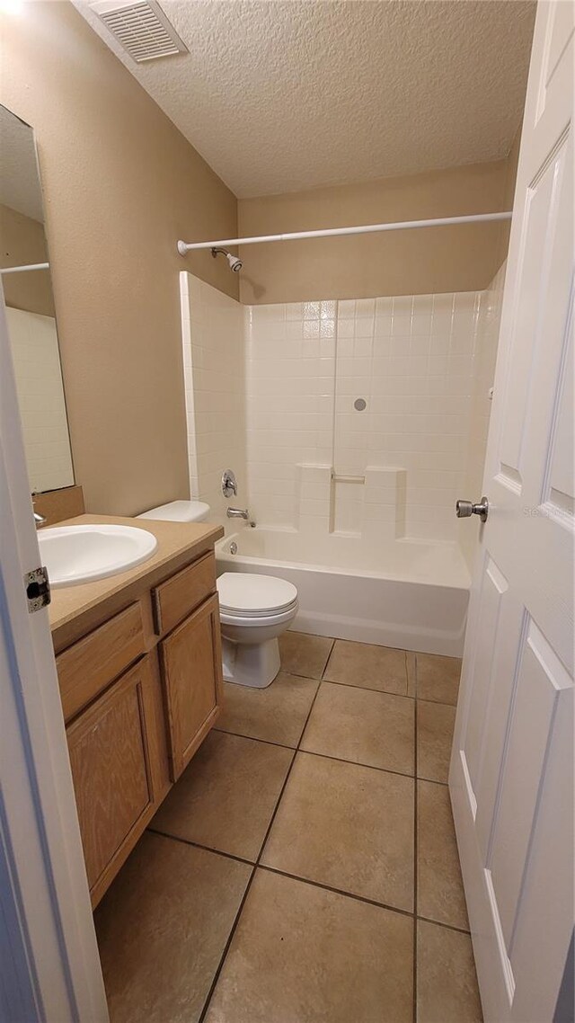 full bathroom with toilet, vanity, tile patterned floors, a textured ceiling, and shower / tub combination