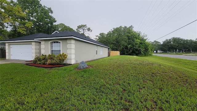 view of home's exterior featuring concrete driveway, a lawn, an attached garage, and stucco siding