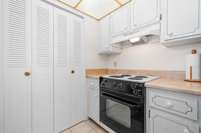 kitchen featuring light tile patterned floors, white cabinets, and black / electric stove