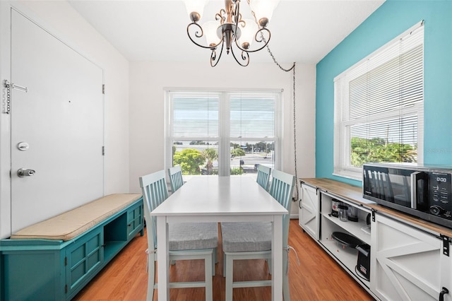 dining room with a notable chandelier, a wealth of natural light, and light hardwood / wood-style flooring