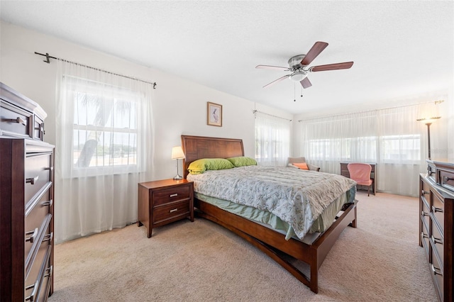 carpeted bedroom with ceiling fan and multiple windows